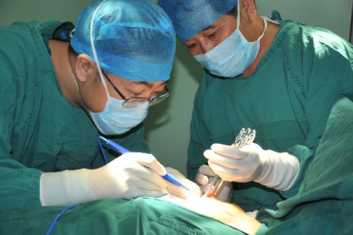 红河州乳腺肿瘤专家杨宝和（右一）为患者手术~1.jpg